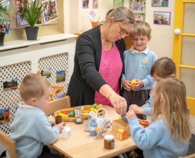 Rookwood Nursery school teacher sat with a table full of nursery pupils