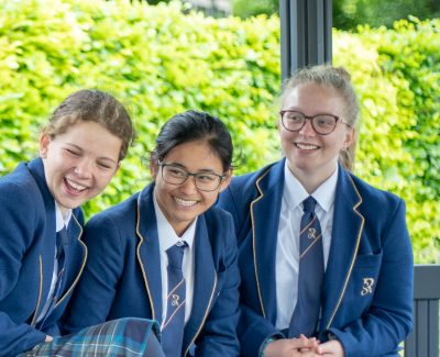 Rookwood School students sat outside on a bench laughing together