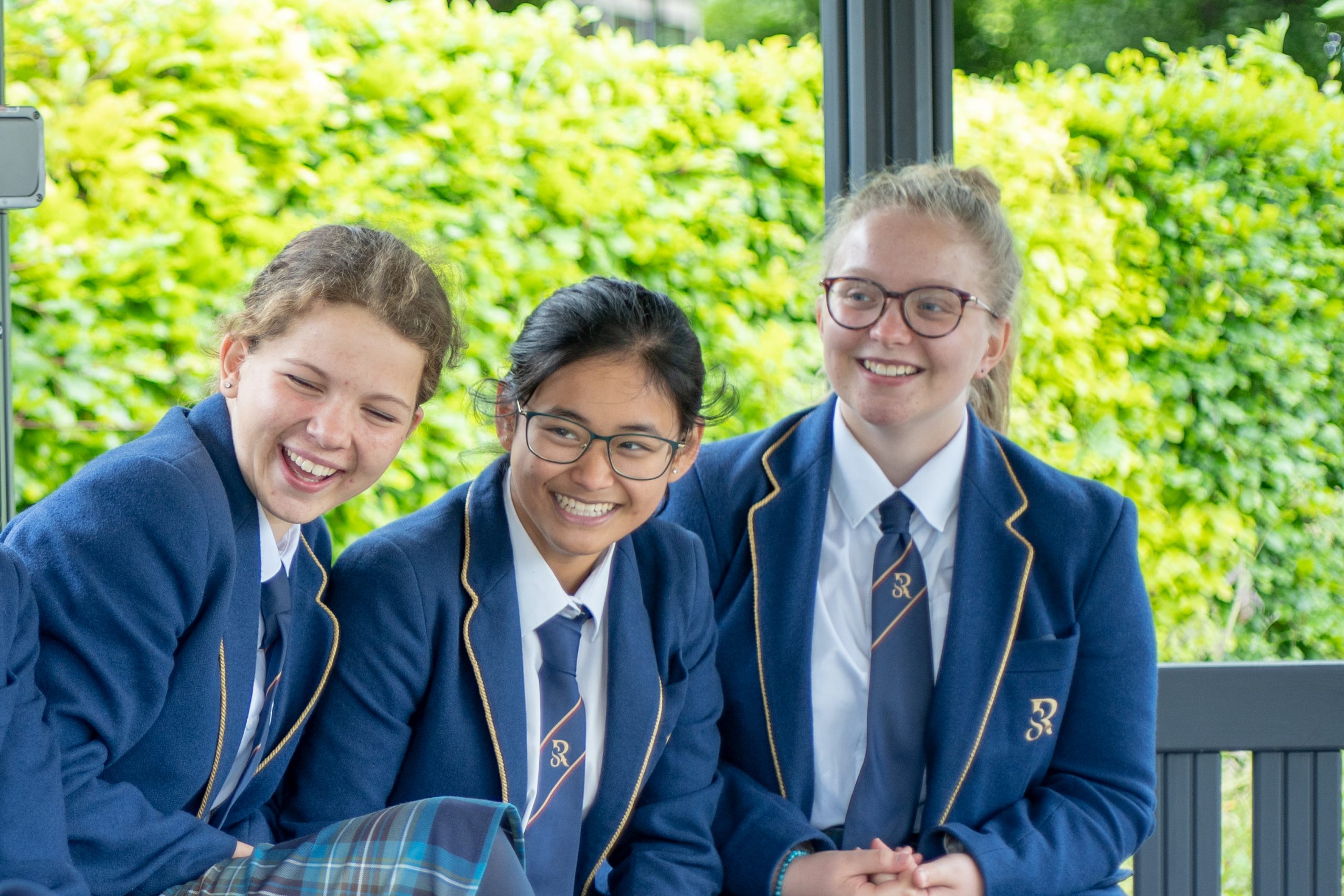 Rookwood School students sat outside on a bench laughing together