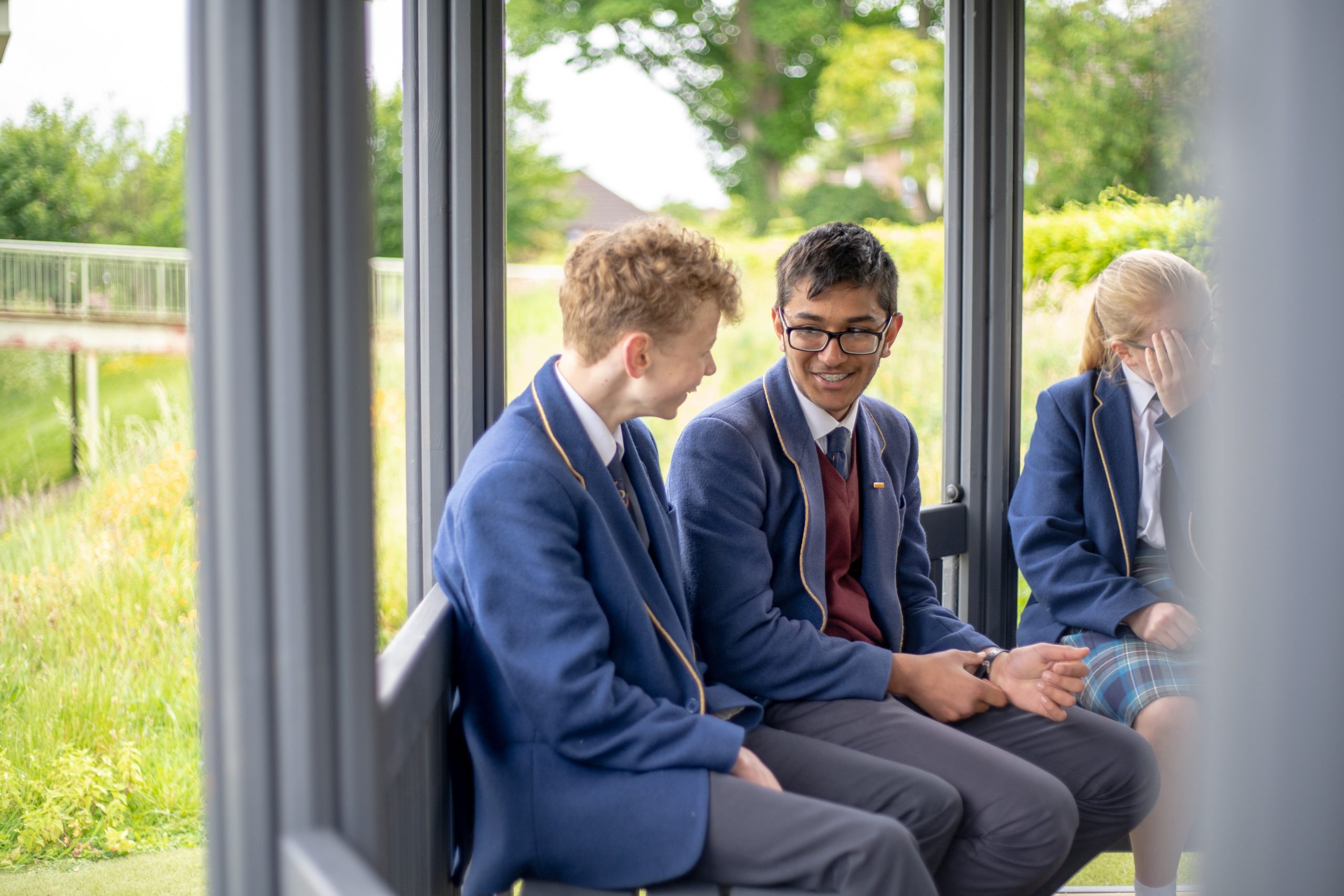 A couple Rookwood School students sat on a bench laughing together