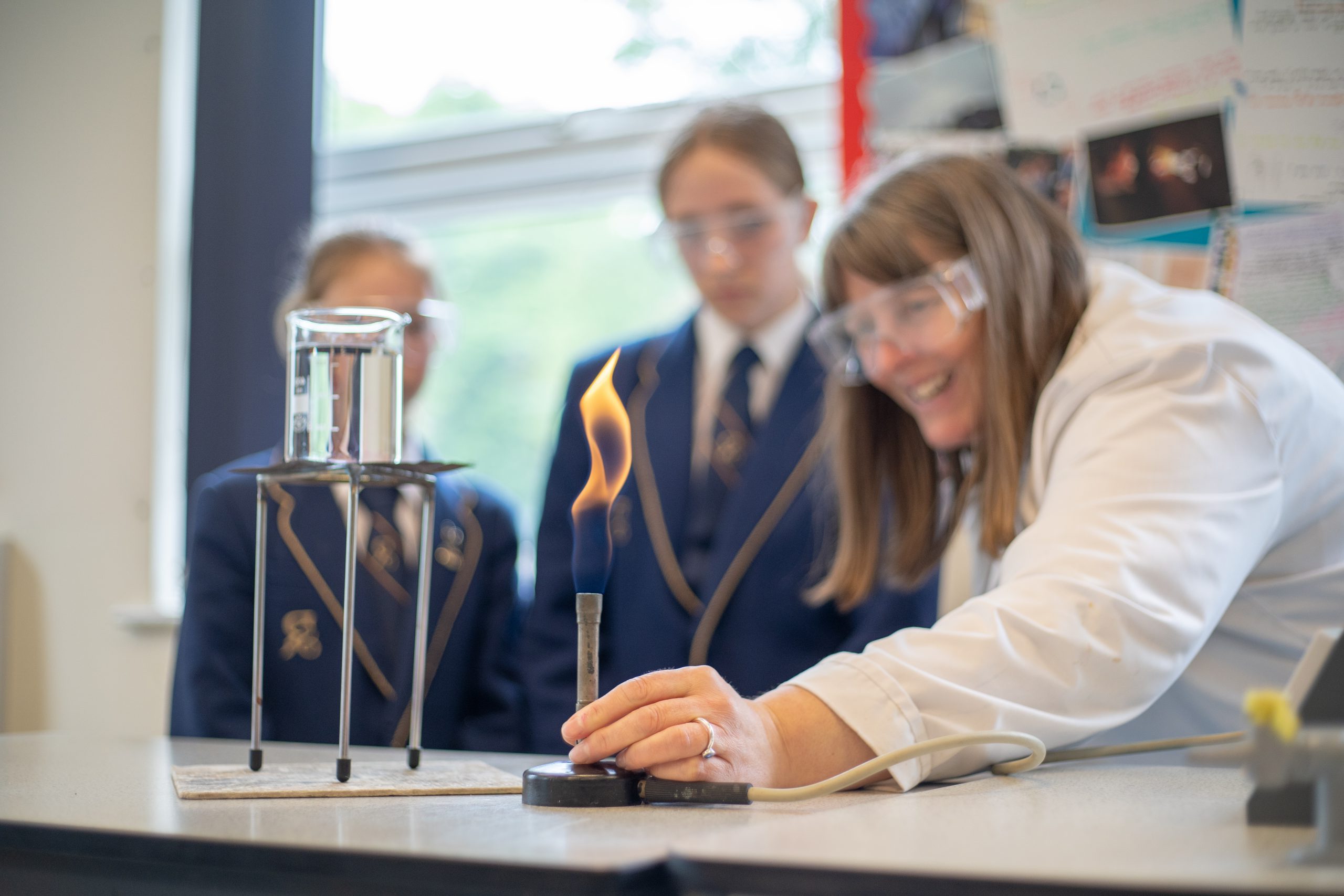 Rookwood School teacher using a Bunsen burner in class while students behind watch