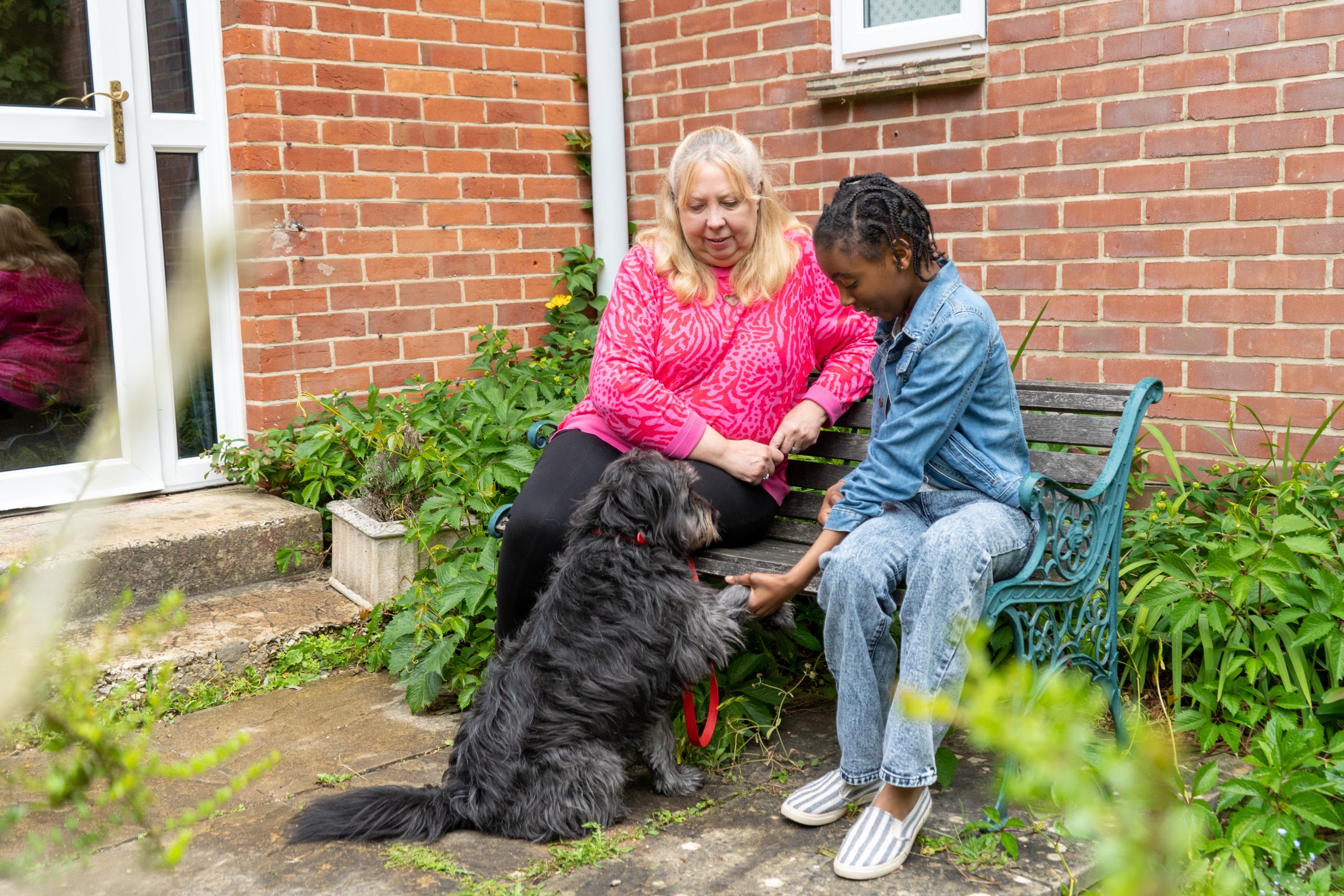 Rookwood School student sat on a bench next to a teacher with a dog in front of them both