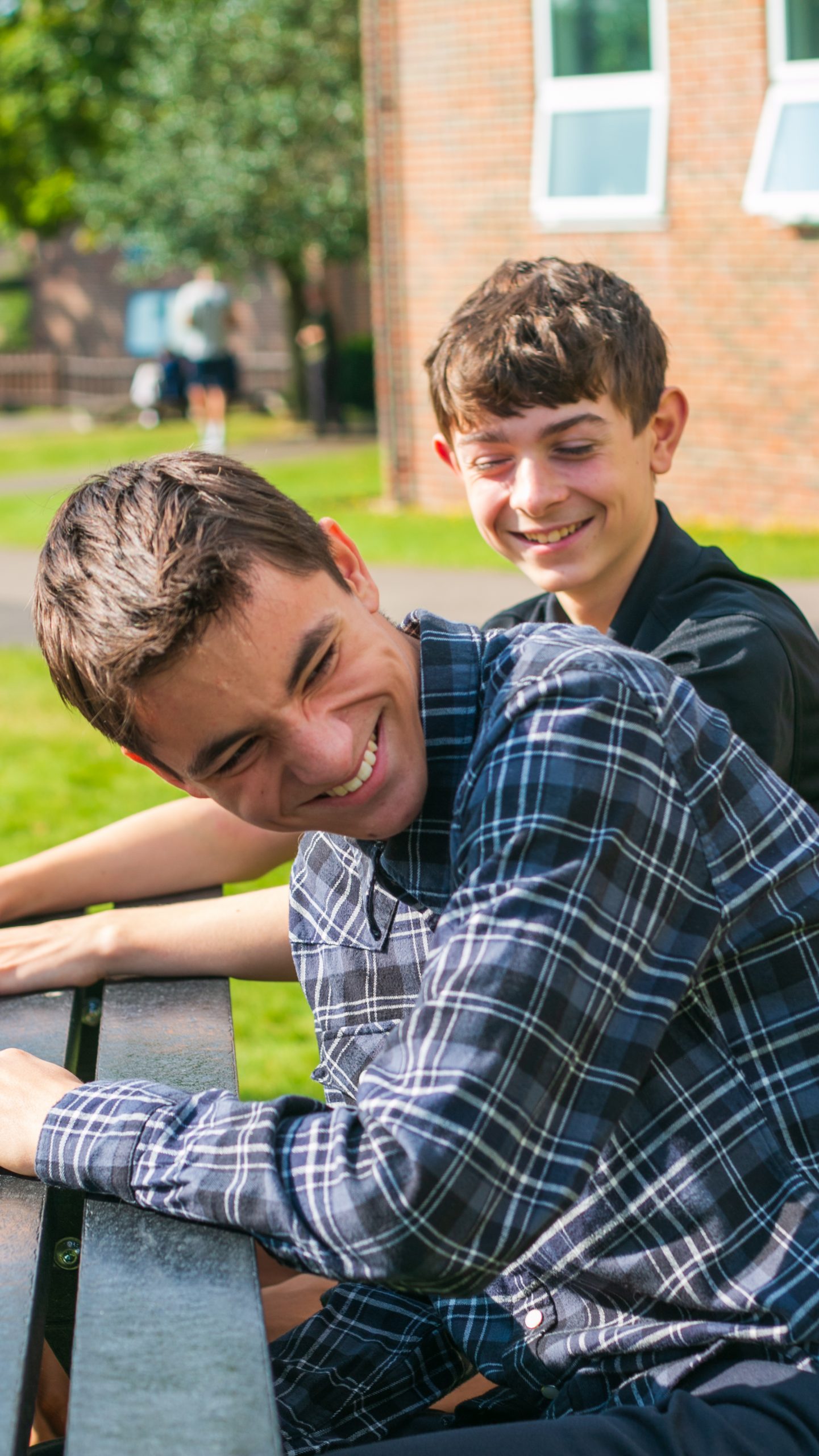 Rookwood Sixth Form Students sat on a bench outside laughing